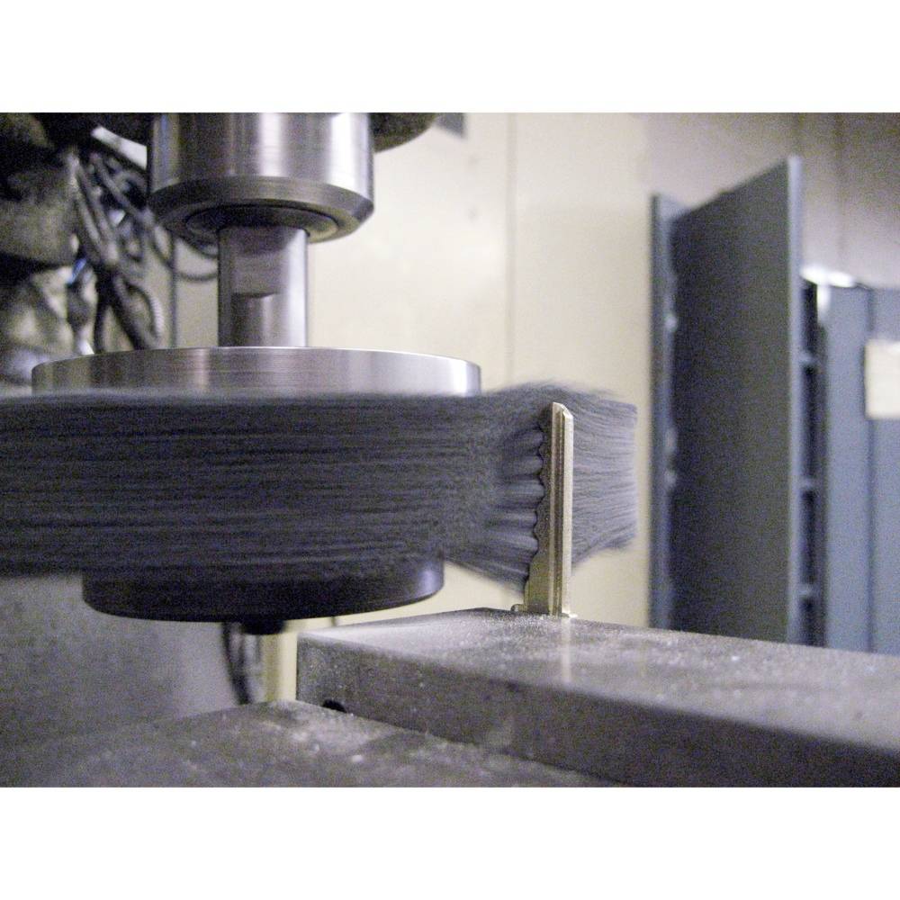 Kovová frézovacia stroj pracuje na obrobku. Fréza sa rýchlo otáča, viditeľné kovové triesky svedčia o aktívnom opracovaní.