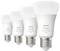 Štyri inteligentné žiarovky Philips Hue modelu "white and color" sú usporiadané v rade, každá s striebornou päticou.