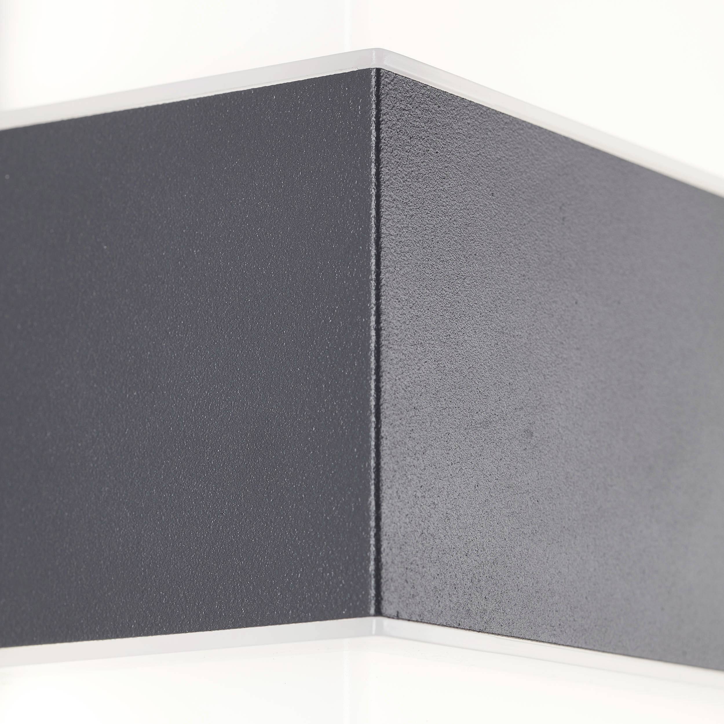 Detailný záber úzkeho, čierneho, pravouhlého objektu s bielym okrajom na rozmazanom pozadí.