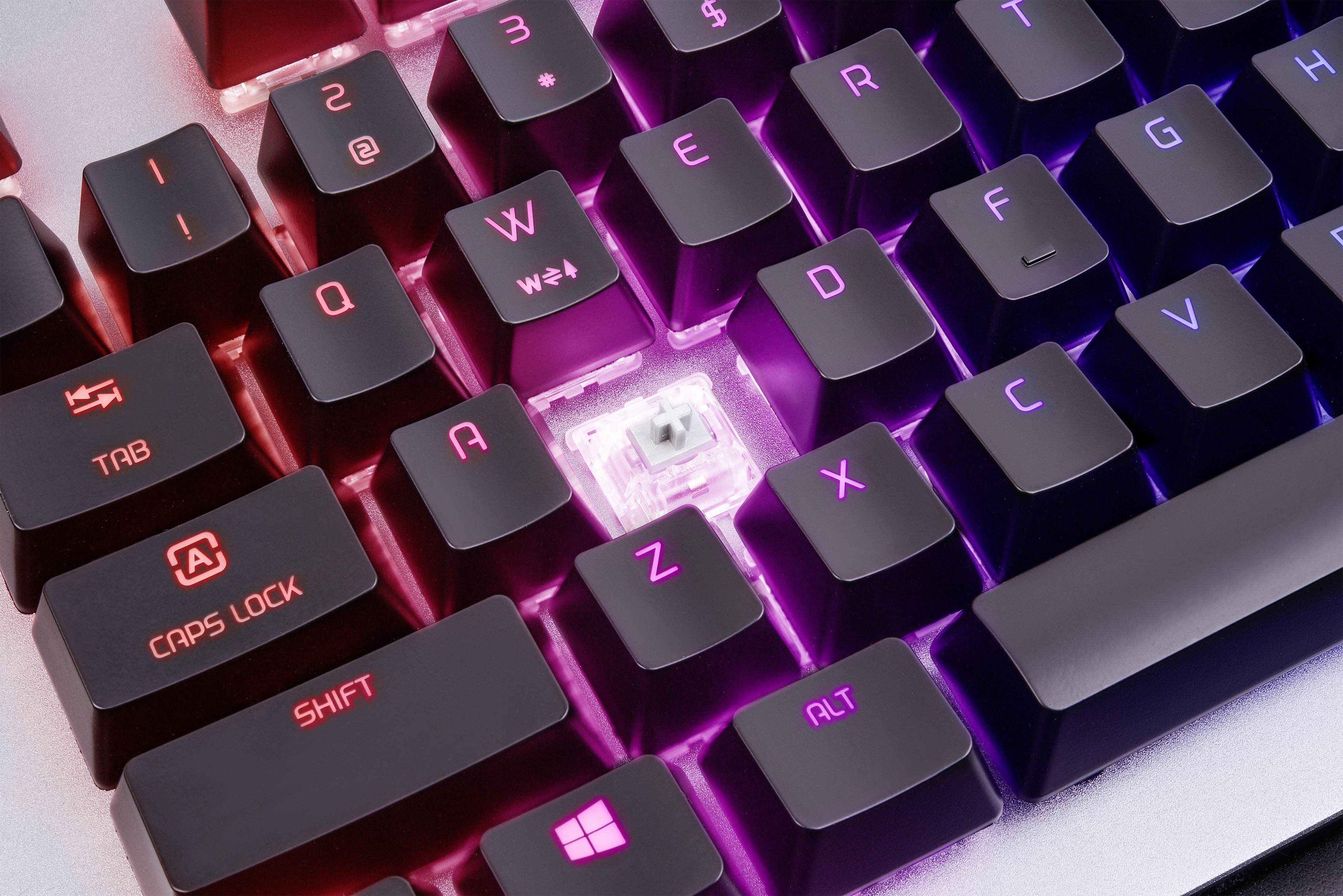 Podsvietená mechanická klávesnica s vyňatou klávesou, ktorá odhaľuje spínač pod ňou. Klávesy svietia v ružovej a fialovej farbe.