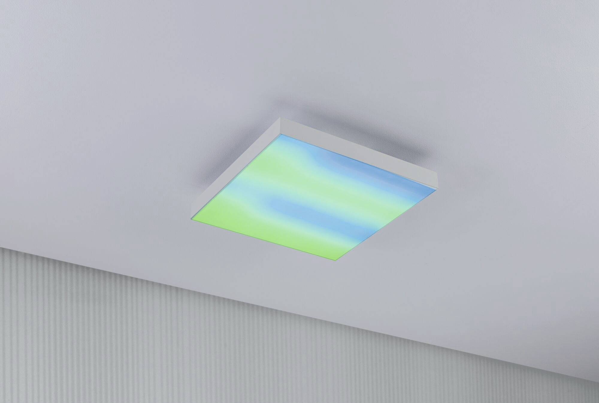 Štvorcový LED panel na strope, ktorý svieti v odtieňoch modrej a zelenej. Slúži na dekoratívne osvetlenie.