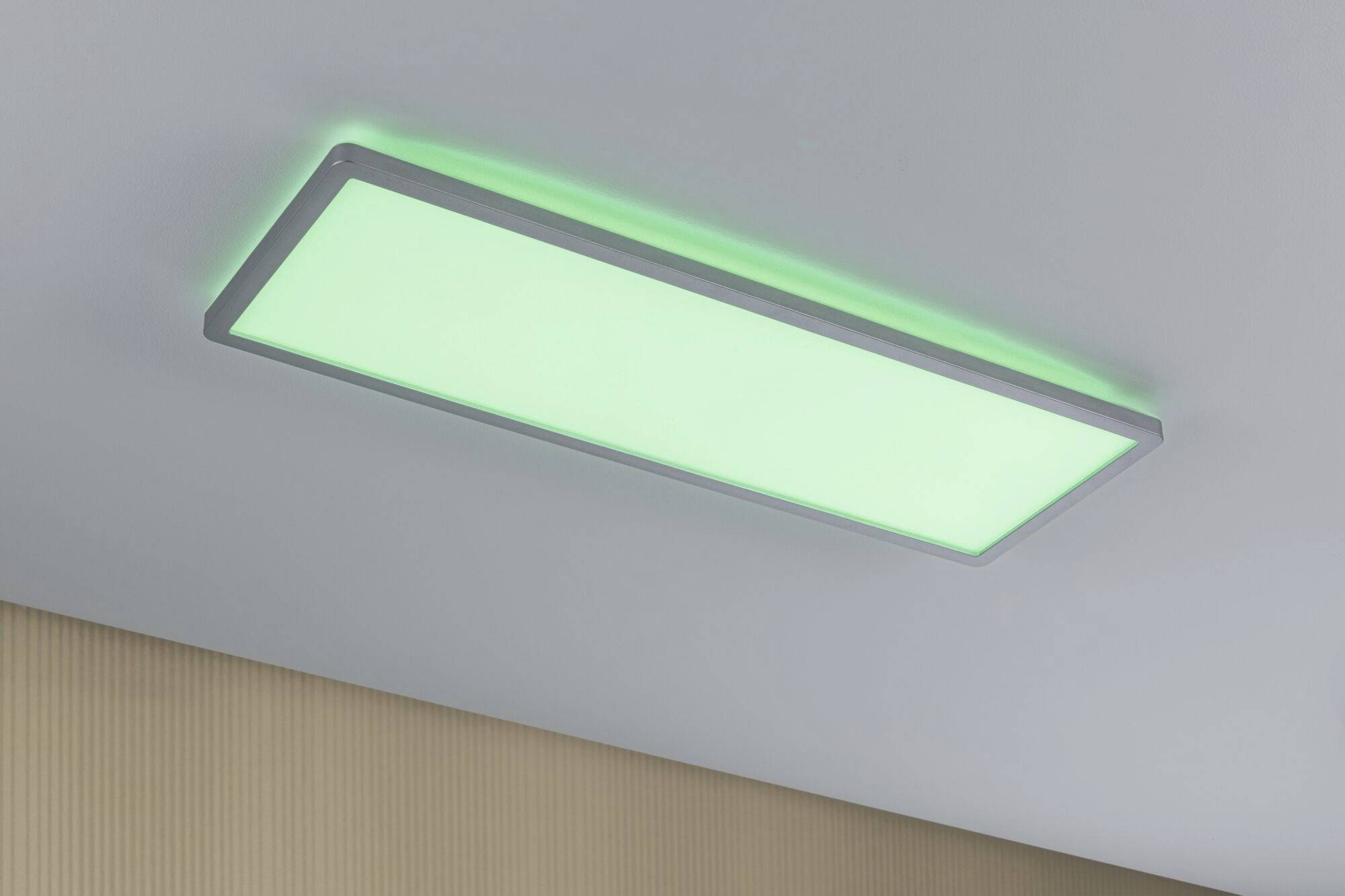 Obdĺžniková LED stropná lampa v miestnosti, ktorá svieti zeleným svetlom.