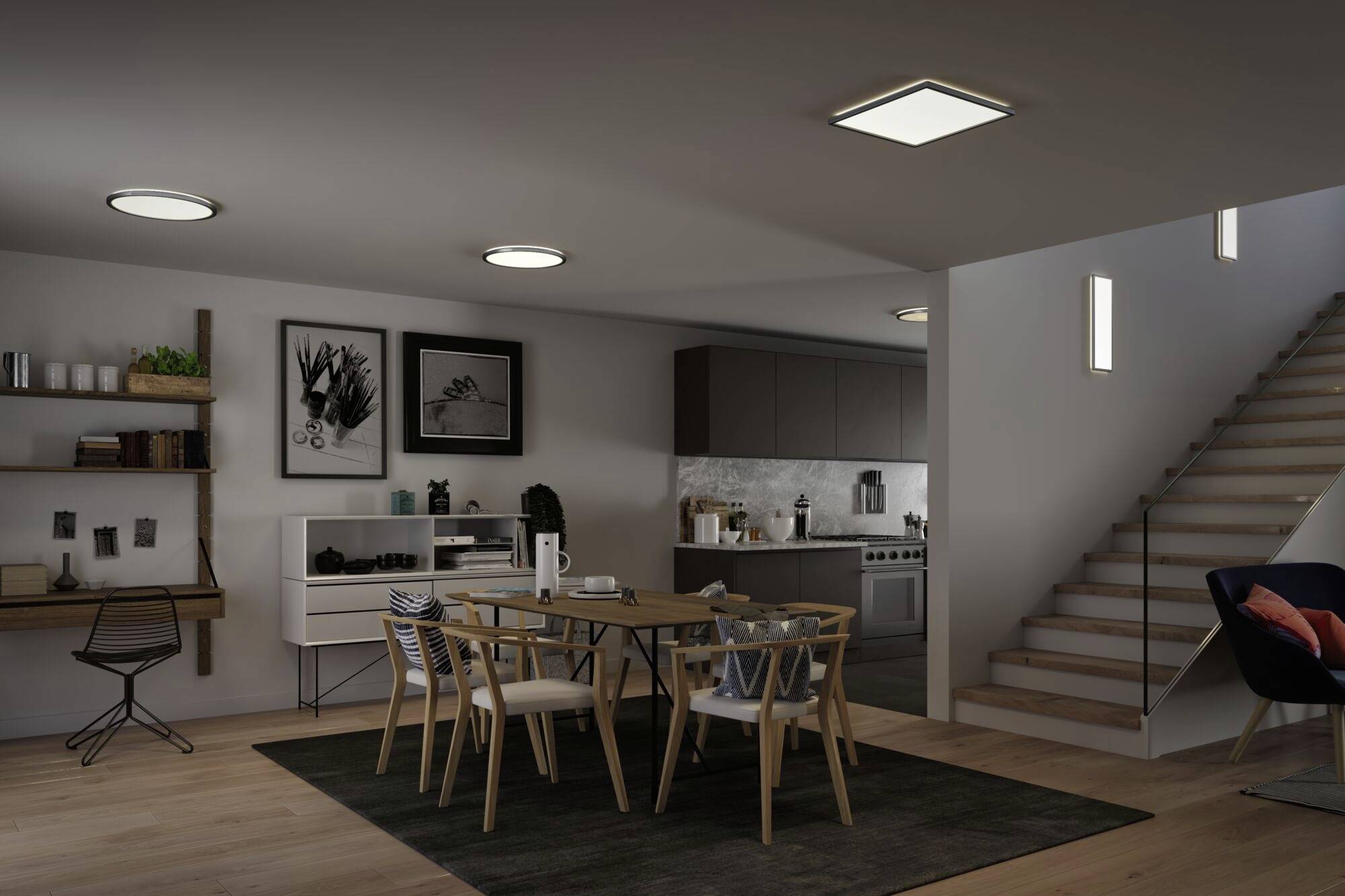 Jedáleň so stolom a stoličkami, moderná kuchyňa v pozadí, schodisko vpravo, tlmené osvetlenie, štýlový interiér.