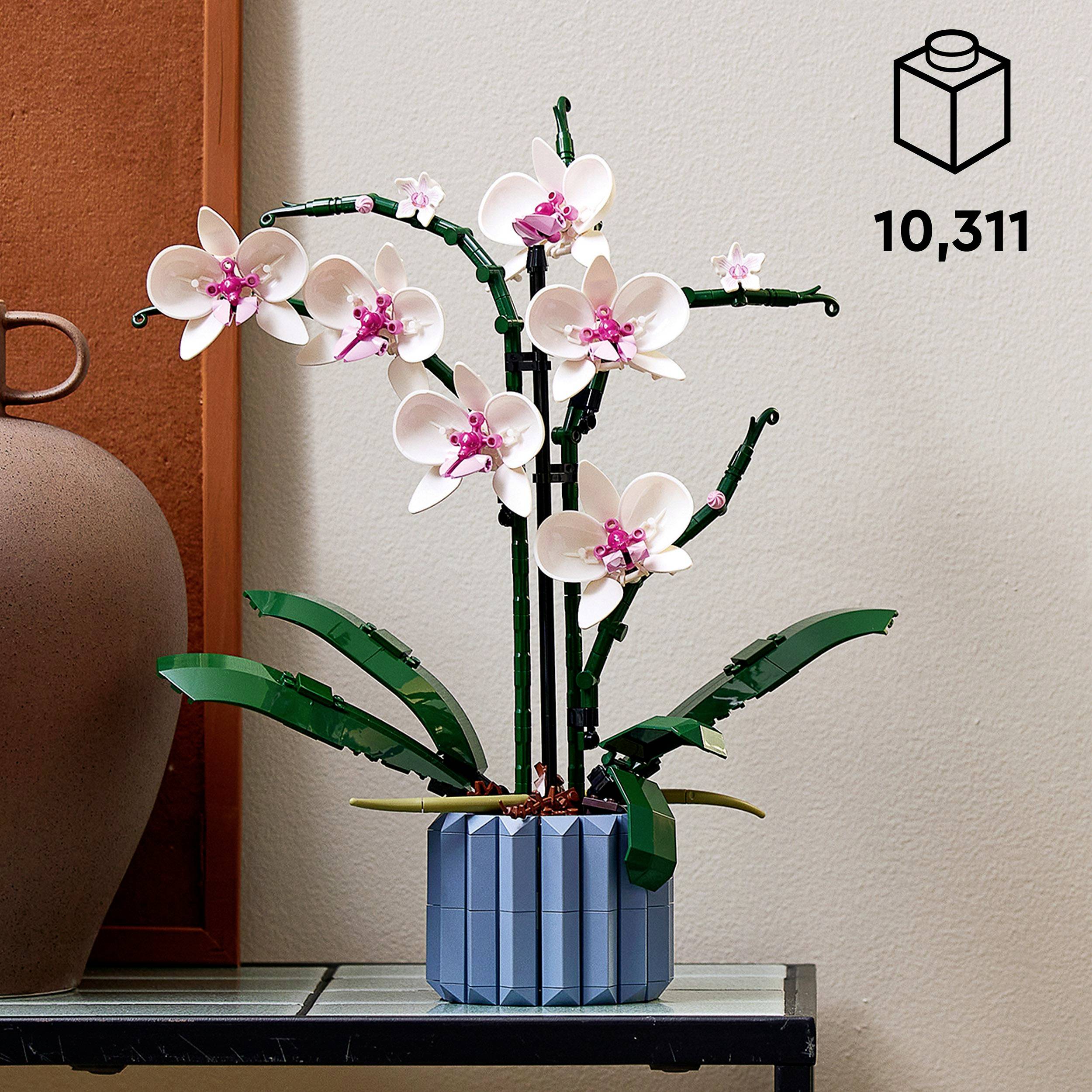 Stavebnica LEGO s orchideou v kvetináči na stole. Vpravo hore je napísané '10,311'.