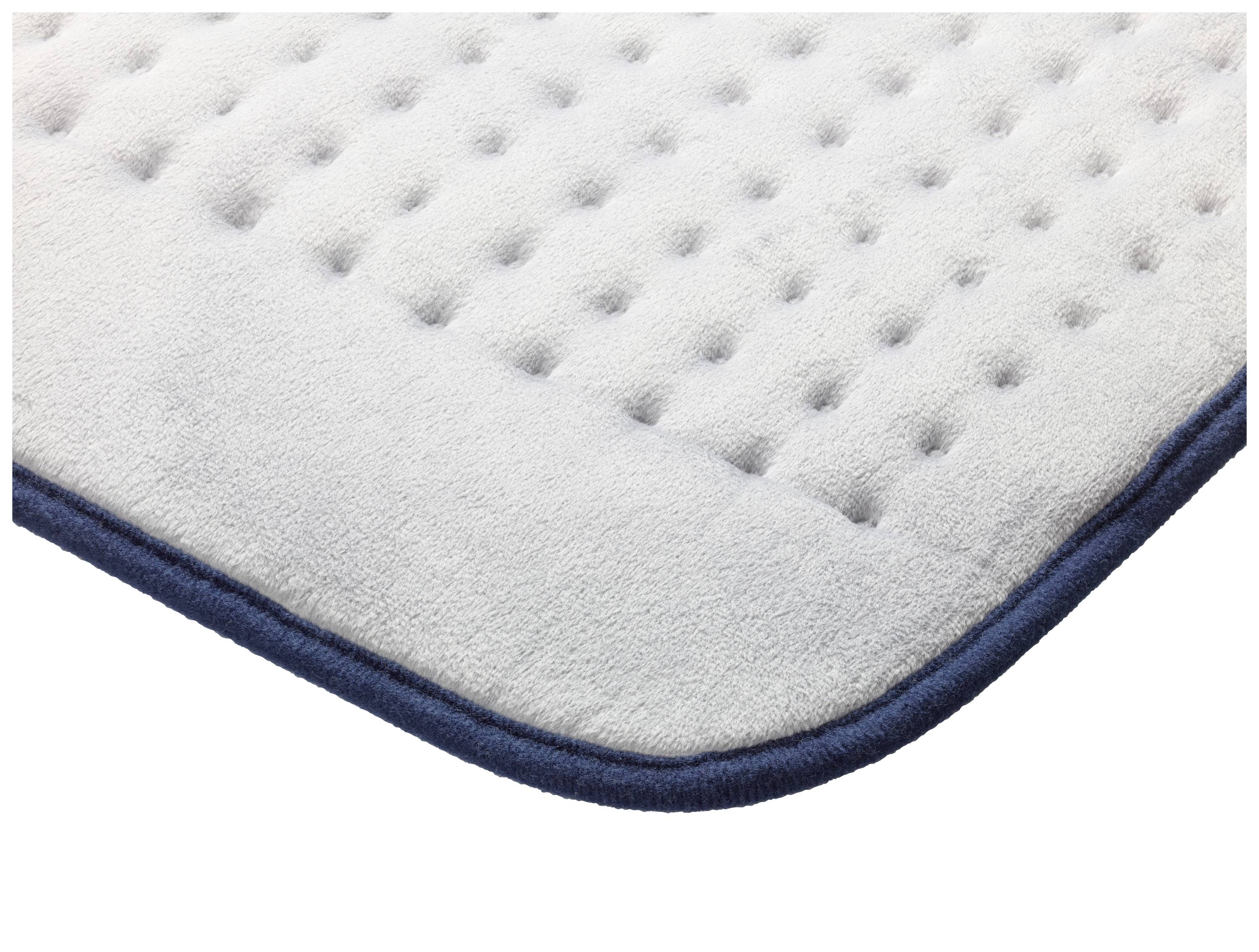 Roh svetlosivej prešívanej podložky s tmavmodrým okrajom a kosoštvorcovou štruktúrou.