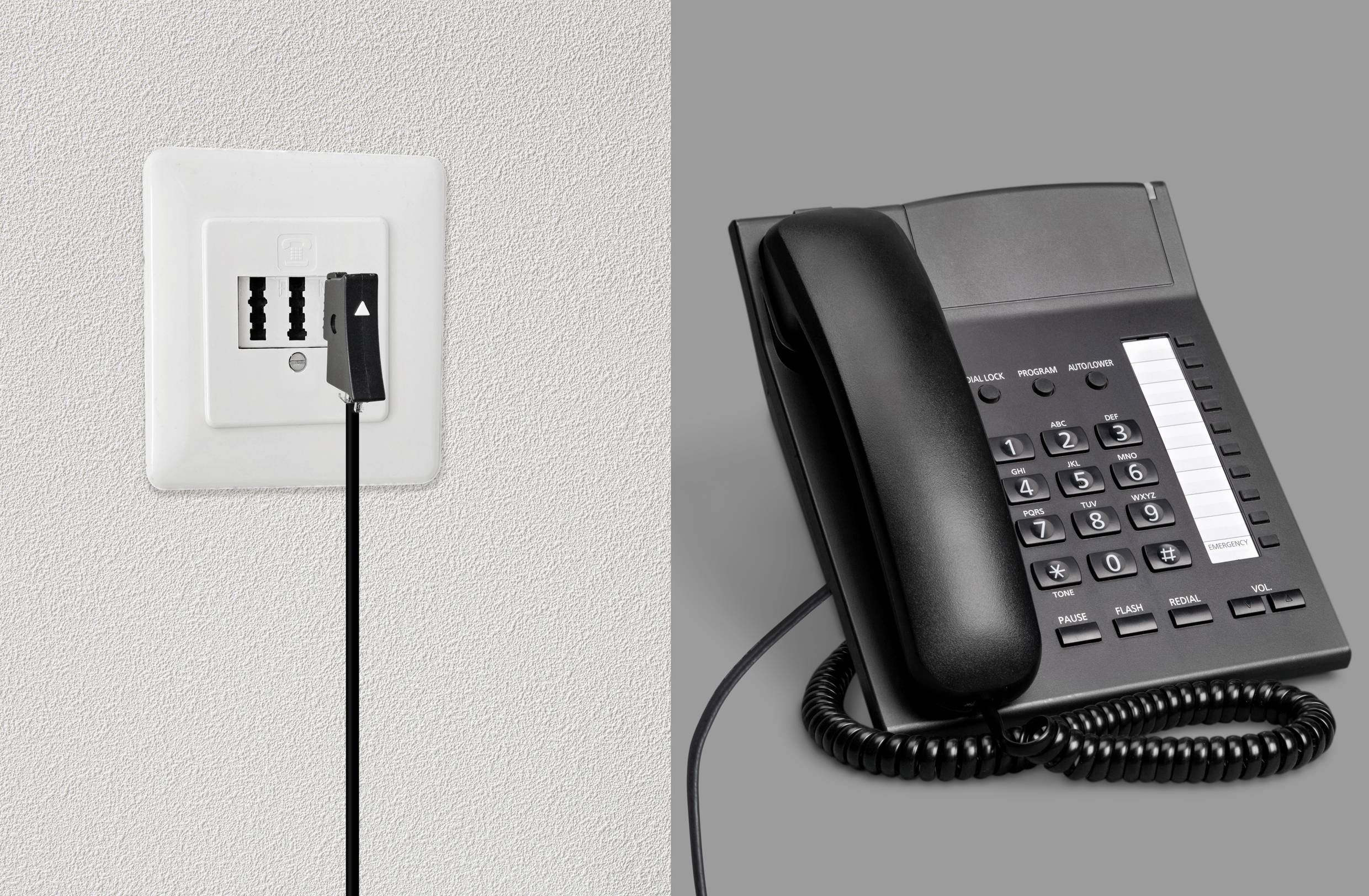 Čierny kábel je pripojený k telefónnemu konektoru vedľa stolového telefónu na sivom pozadí.