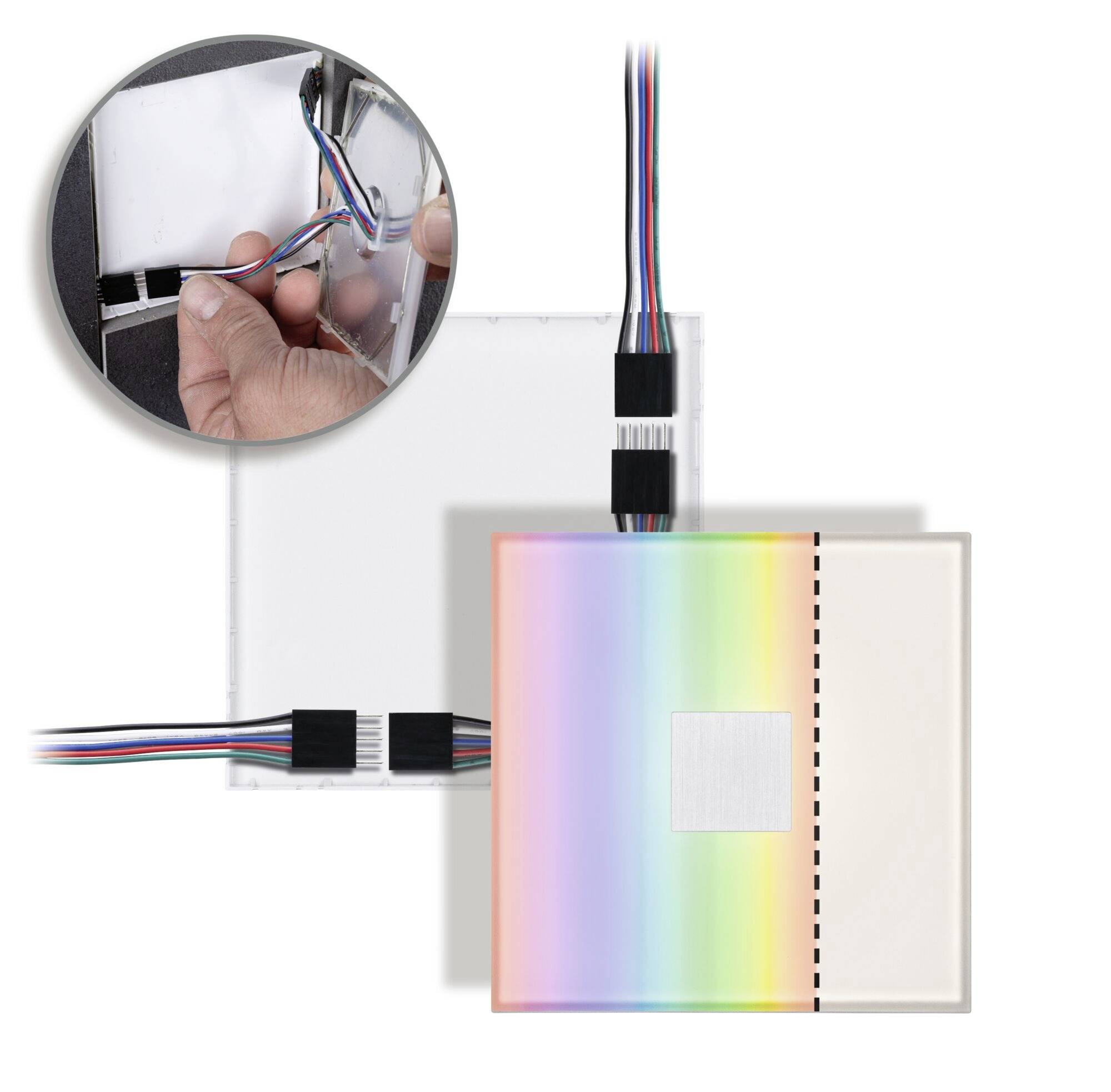 Štvorcový panel s dúhovým efektom a káblovými pripojeniami je zobrazený. Zväčšený záber ukazuje ruku, ktorá drží kábel.