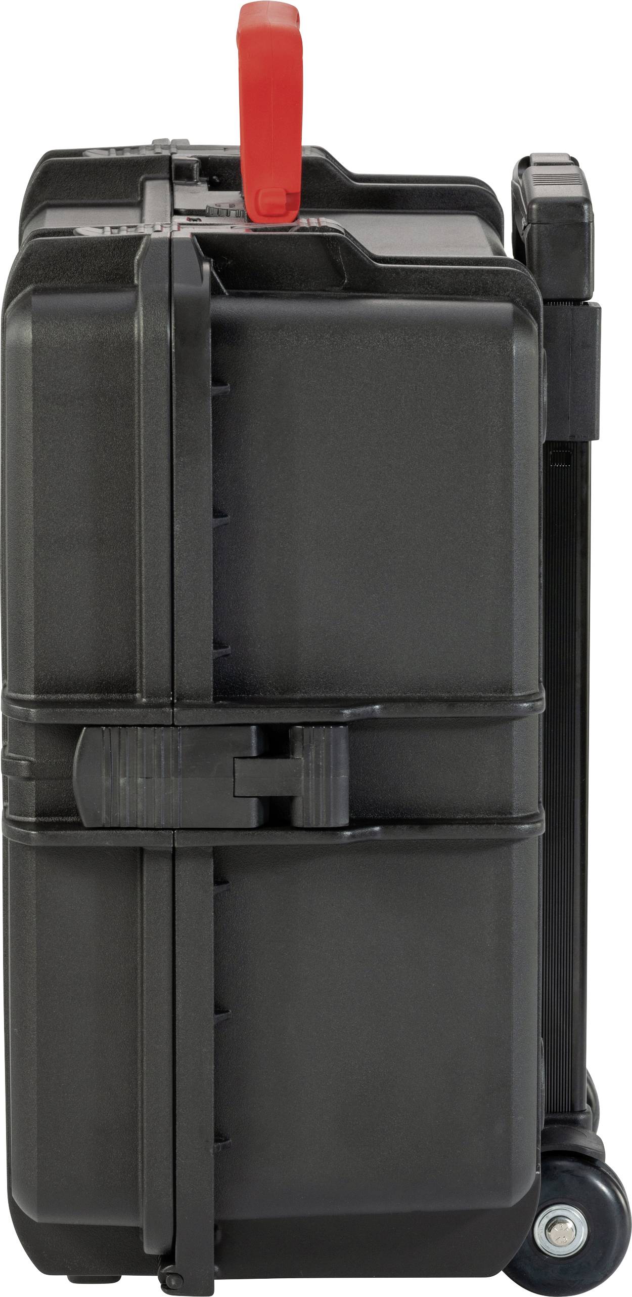 Čierny cestovný kufor s červenou rukoväťou, pohľad z boku, stojaci na dvoch kolieskach.