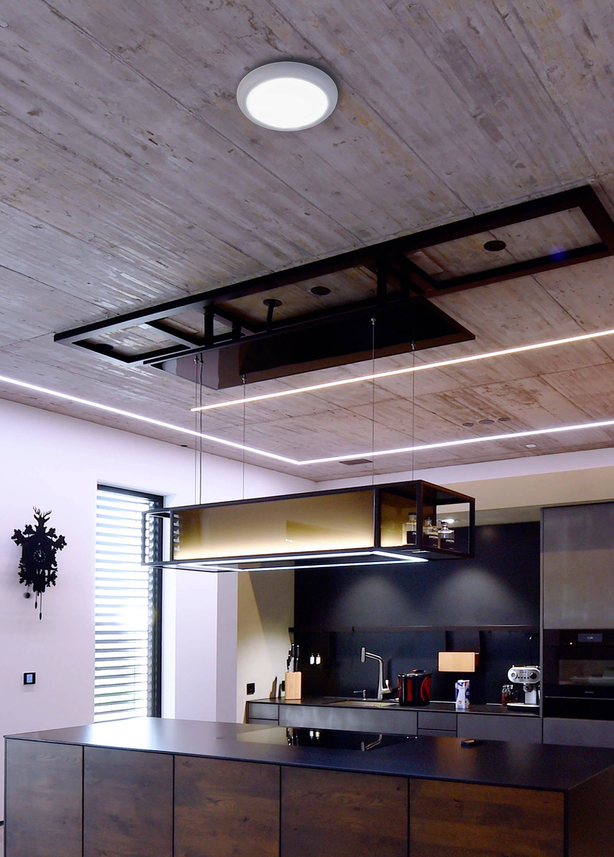 Moderná kuchyňa so zavesením, obdĺžnikovým digestorom z kovu a skla nad kuchynským ostrovčekom. Strop pokrytý drevenými panelmi.