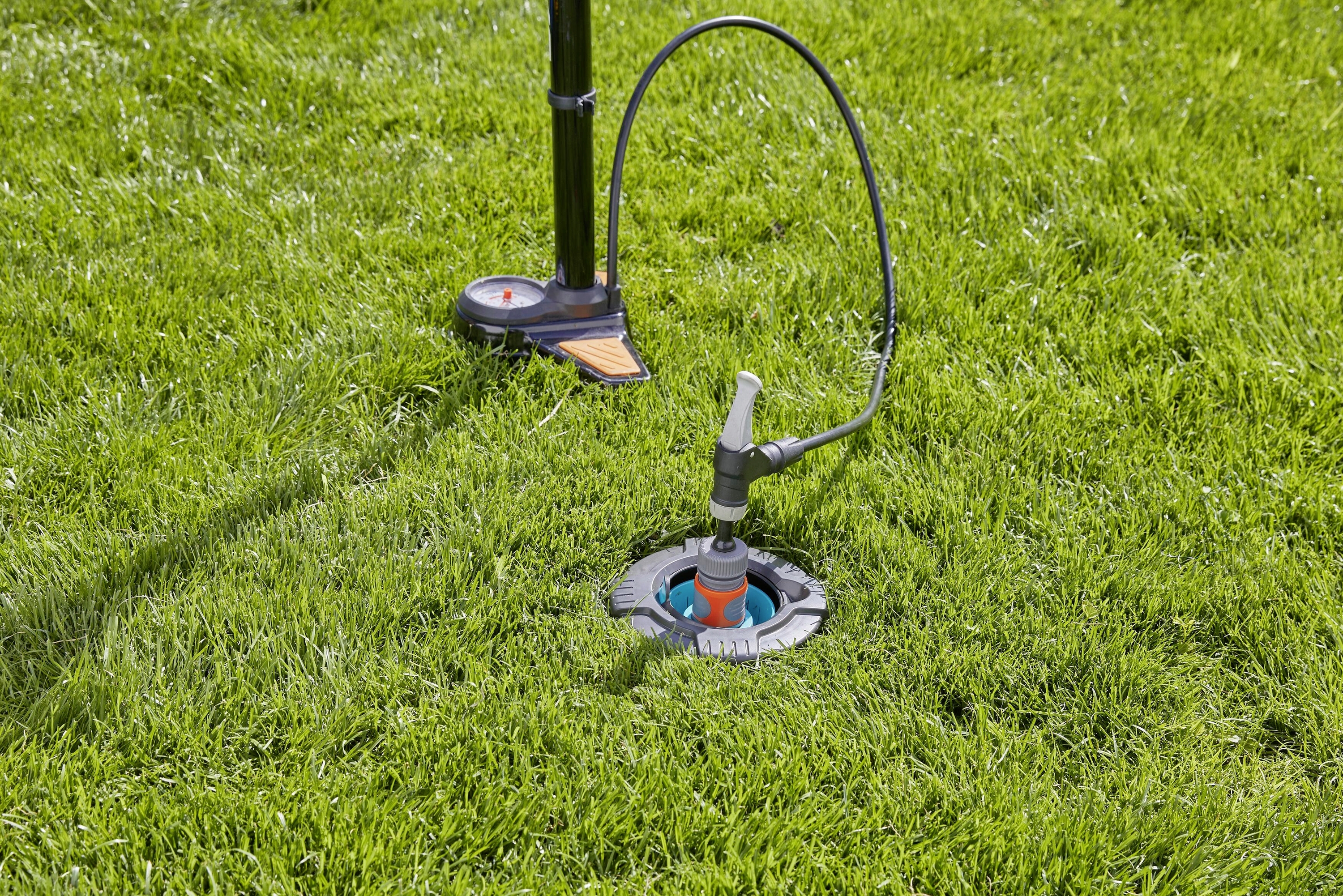 Na trávniku nainštalovaný zavlažovací systém je ovládaný tlakovým ventilom umiestneným na stojane.