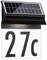 Solárne osvetlená orientačná tabuľa s číslom '27c'. Čierna solárna fotovoltaická doska v hornej časti, biela osvetlená plocha v spodnej časti.