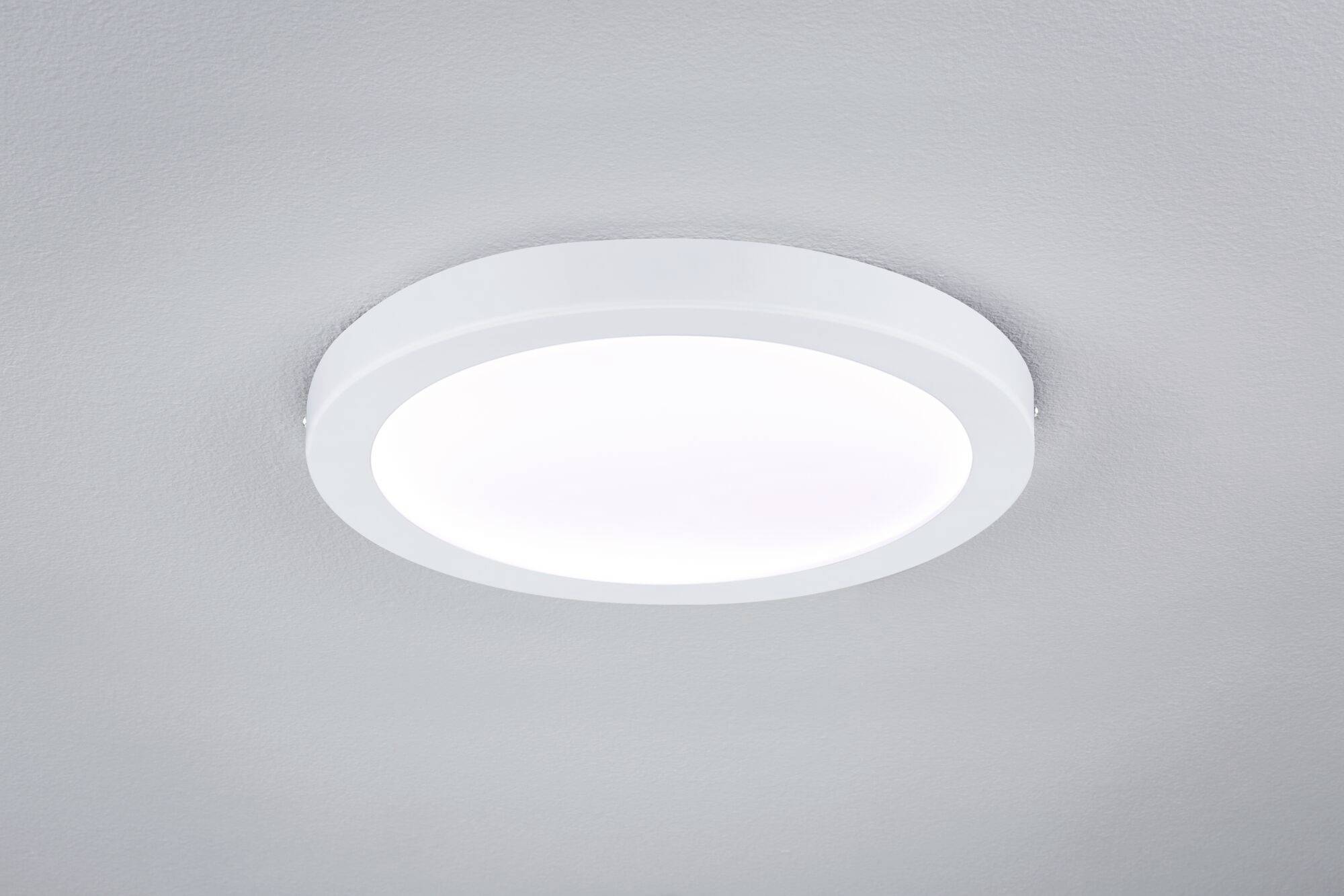 Okrúhle, biele stropné svietidlo s moderným, plochým dizajnom, ktoré vyžaruje rovnomerné, rozptýlené svetlo.