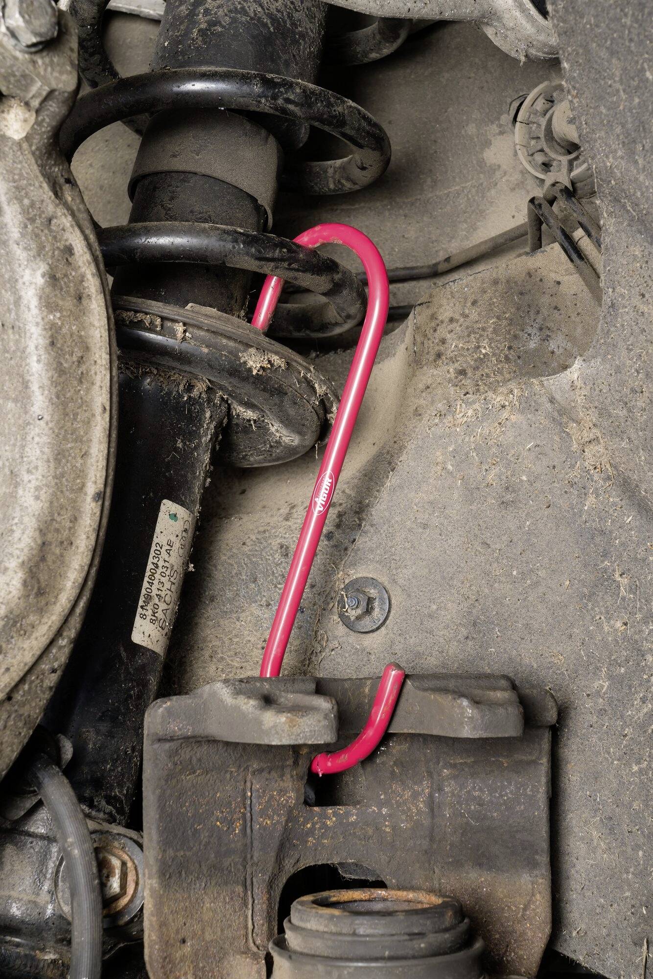 Červený zámok na volante auta, ktorý chráni pred krádežou tým, že blokuje riadenie.