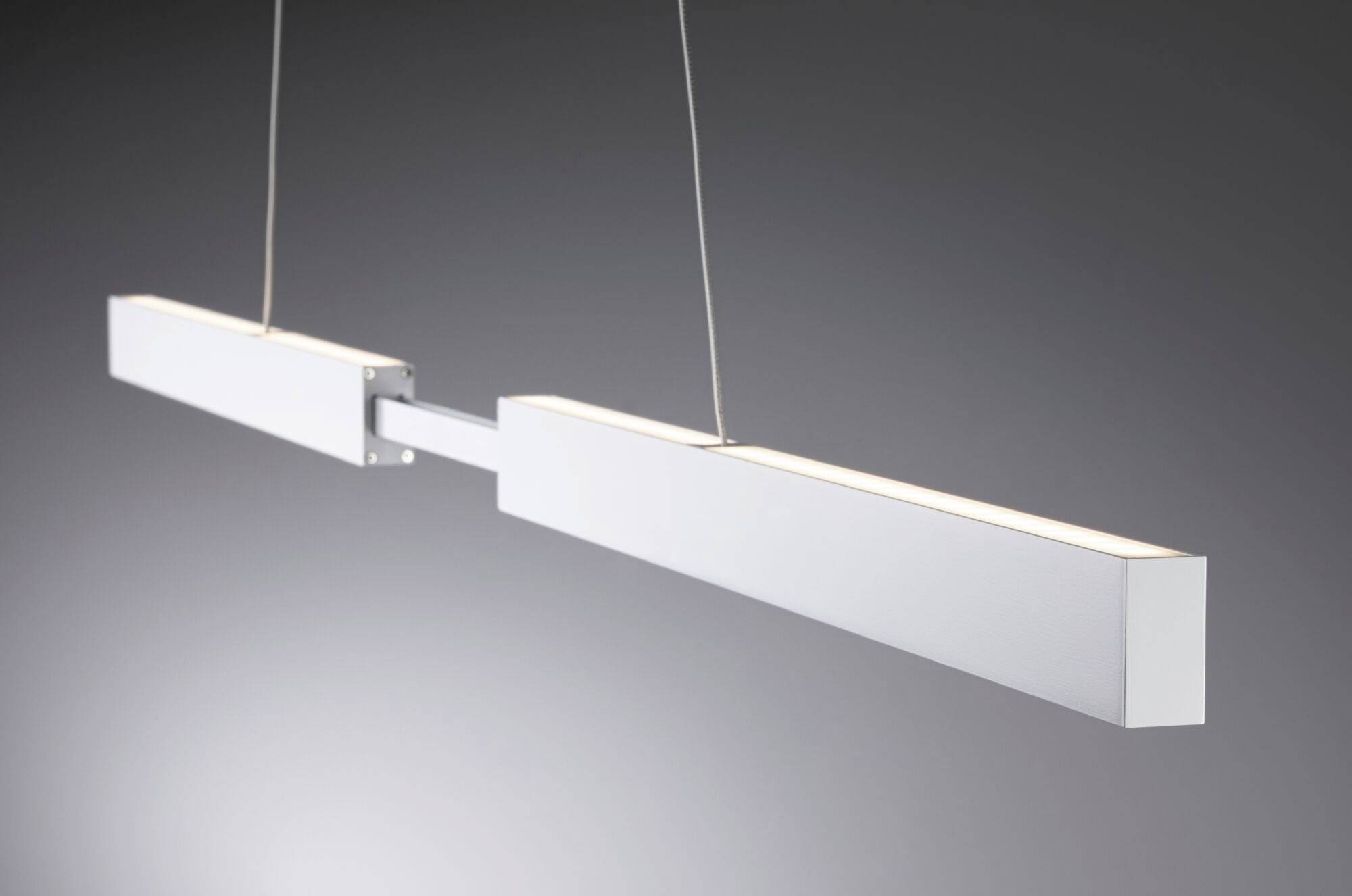 Moderná závesná lampa s dvoma obdĺžnikovými, podlhovastými svetelnými telesami, ktoré visia na lanách od stropu, pred sivým pozadím.