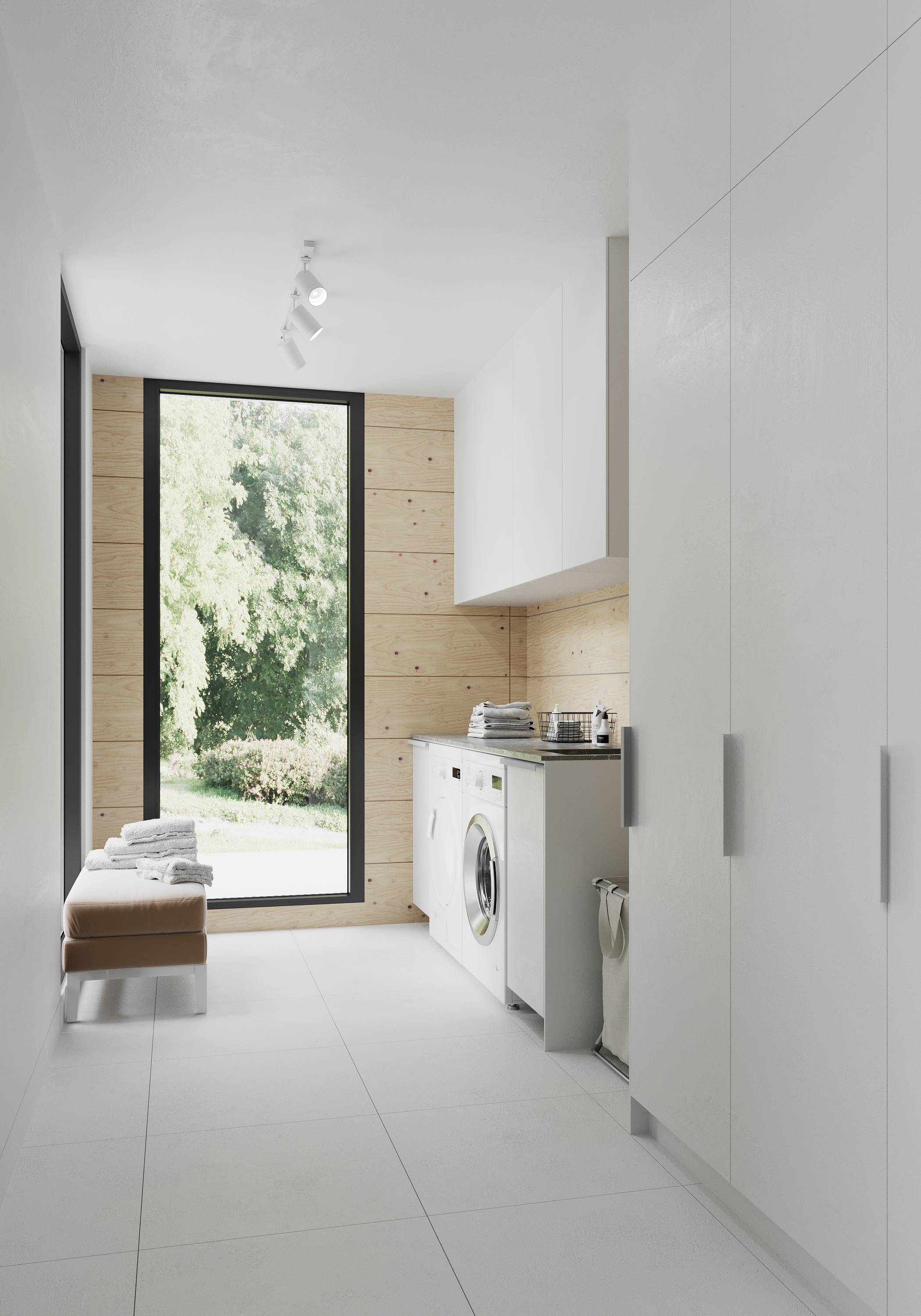 Svetlá práčovňa s veľkými oknami, bielymi skrinkami, práčkou a sušičkou, s výhľadom na zelenú záhradu.