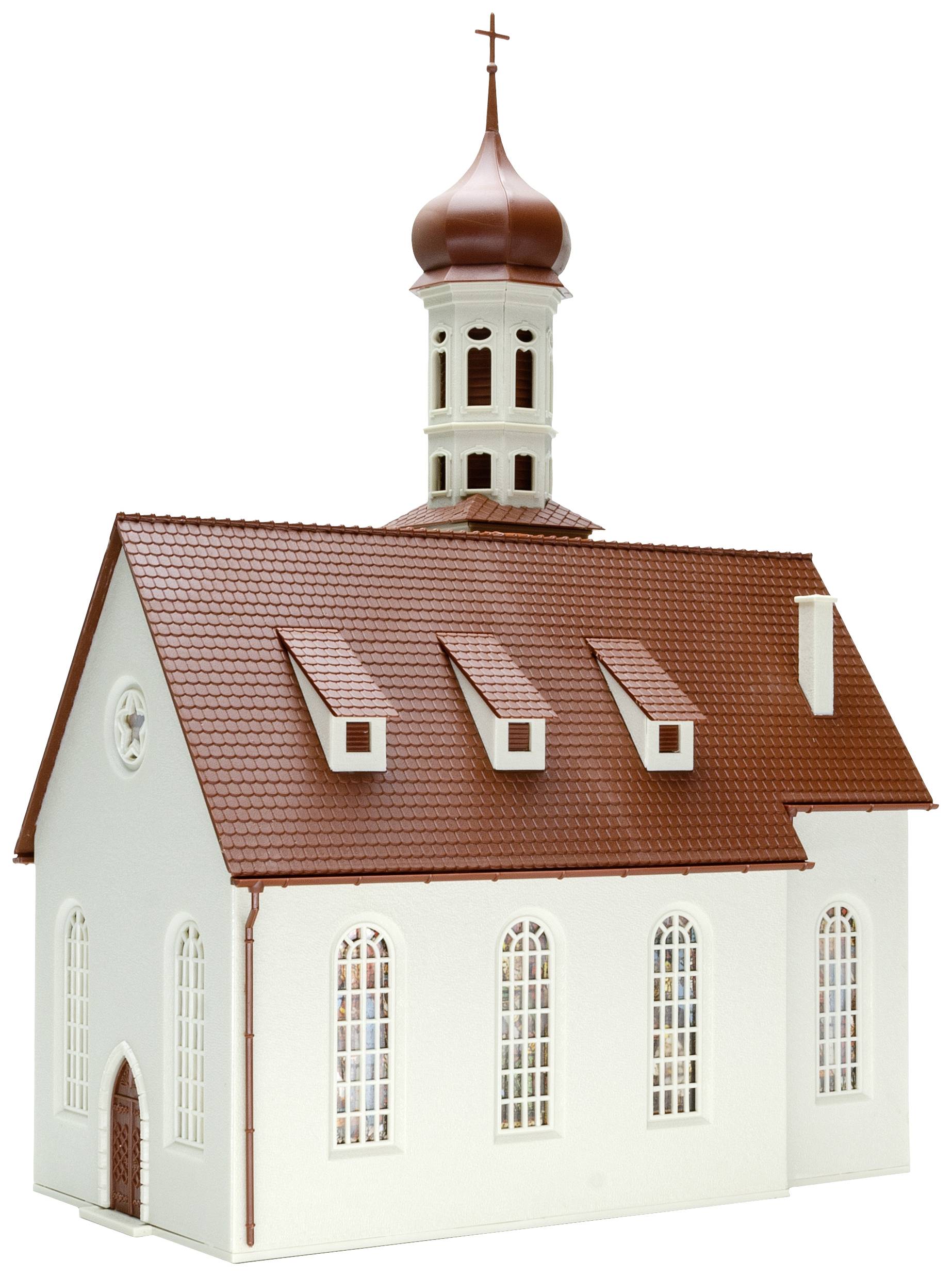 Malý model bielého kostola s červenou strechou a vežou, ktorá je korunovaná krížom.