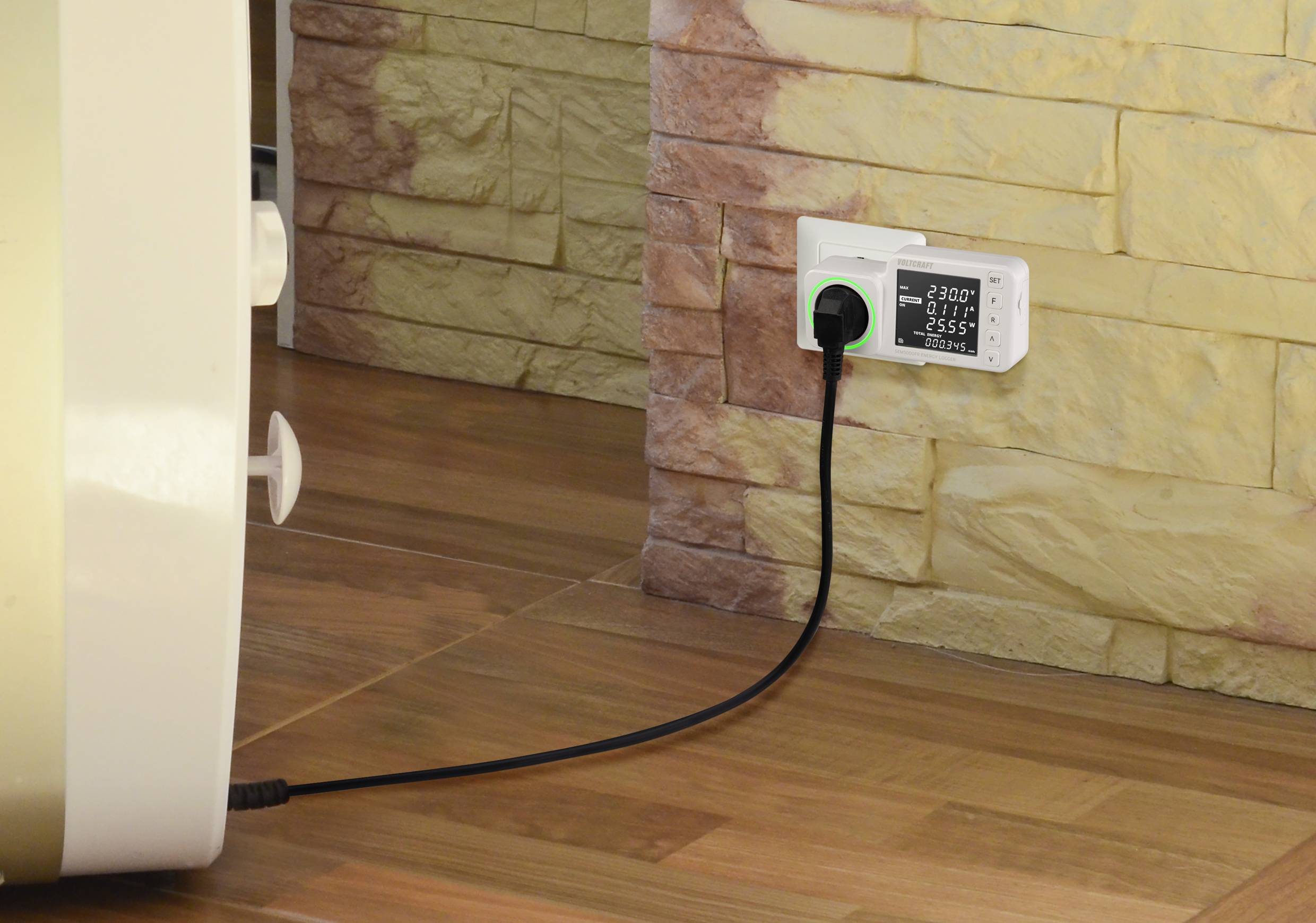 Elektrická zásuvka s meračom spotreby elektrickej energie zapojeným do elektrickej zásuvky na stene. Z meracieho zariadenia vedie kábel k nejakému prístroju.