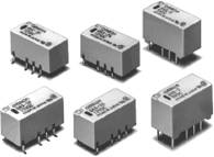 Šesť obdĺžnikových elektronických súčiastok, pravdepodobne relé, so zástrčkovými kontaktmi, usporiadaných do dvoch radov.