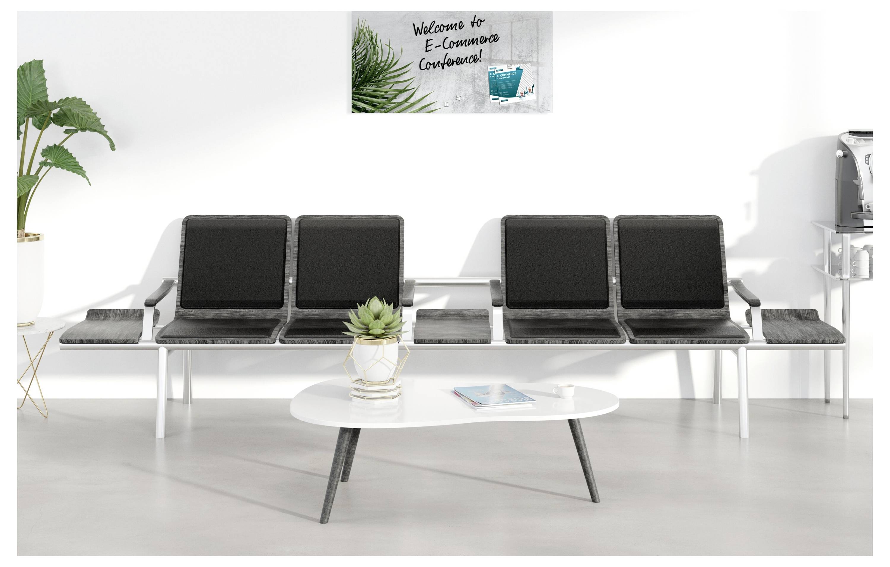 Moderná čakáreň so štyrmi čiernymi stoličkami, vedľajšími stolmi, konferenčným stolíkom, rastlinami a tabuľou s nápisom "Vitajte na E-Consultation Conference".