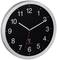 Čierne rádiové nástenné hodiny so strieborným okrajom, bielymi číslicami a ručičkami. Sekundová ručička je červená. Čas: 10:09.