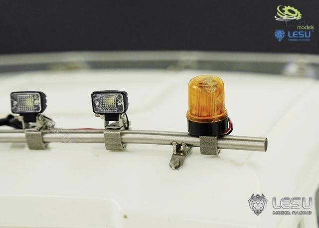 Strešná montáž s dvoma LED svetlami a oranžovým výstražným svetlom na kovovej tyči; detailný pohľad na modelové vozidlo.