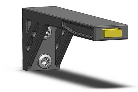 3D model čierneho, uhlovitého držiaka s žltým vstavaným prvkom na prednej hrane. Na základni sú viditeľné skrutky.