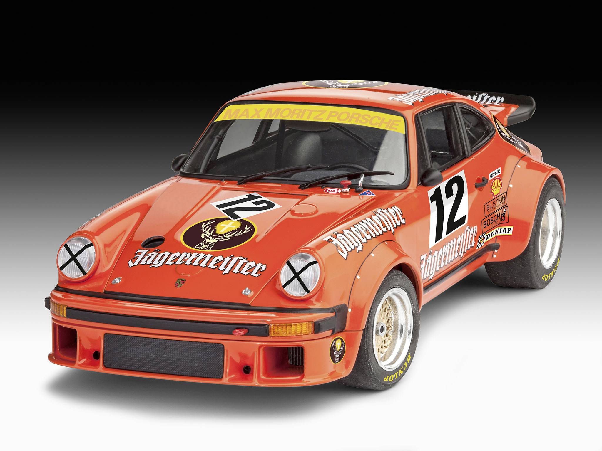 Červené pretekárske auto značky Porsche so štartovným číslom 12 a logami Jägermeister je nasmerované šikmo dopredu.