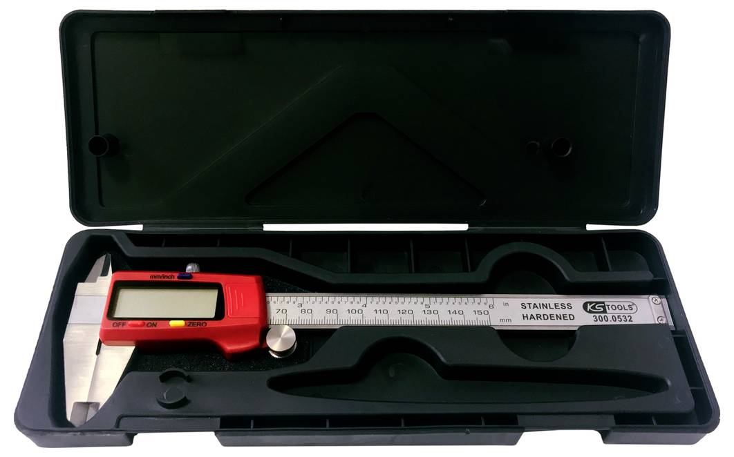 Digitálne posuvné meradlo leží v čiernom plastovom puzdre. Posuvné meradlo má červenú zobrazovaciu jednotku s LCD displejom.