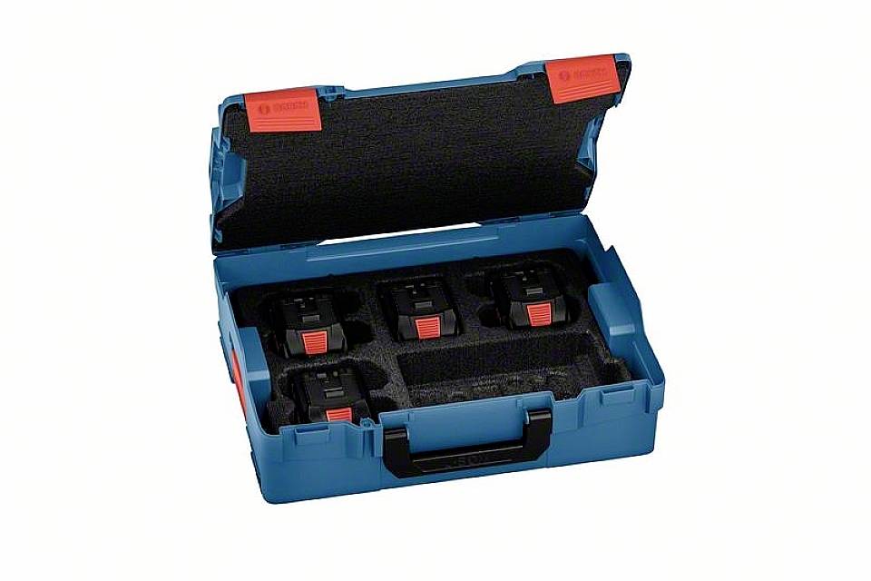 Otvorená modrá škatuľa s čiernou penovou výstelkou obsahuje štyri elektronické zariadenia s červenými tlačidlami, pravdepodobne batérie.