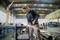 Osoba v ochranných okuliaroch a rukaviciach brúsi kov uhlovou brúskou v priemyselnej dielni. Okolo lietajú iskry.