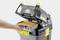 Osoba vkladá filter do otvoreného priestoru profesionálneho vysávača Kärcher.