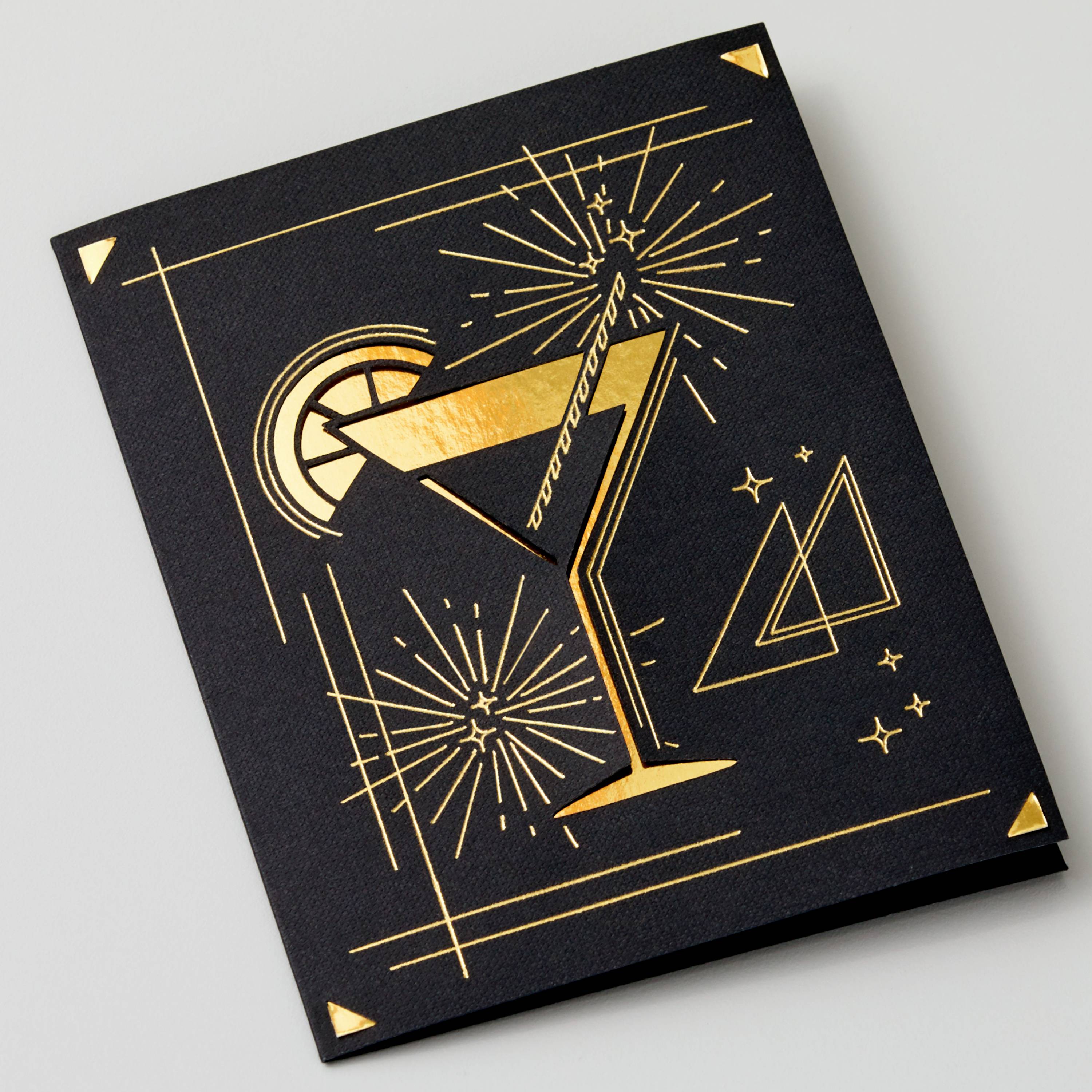 Čierna karta so zlatou ilustráciou koktailu a geometrickými vzormi pripomínajúcimi štýl art deco.