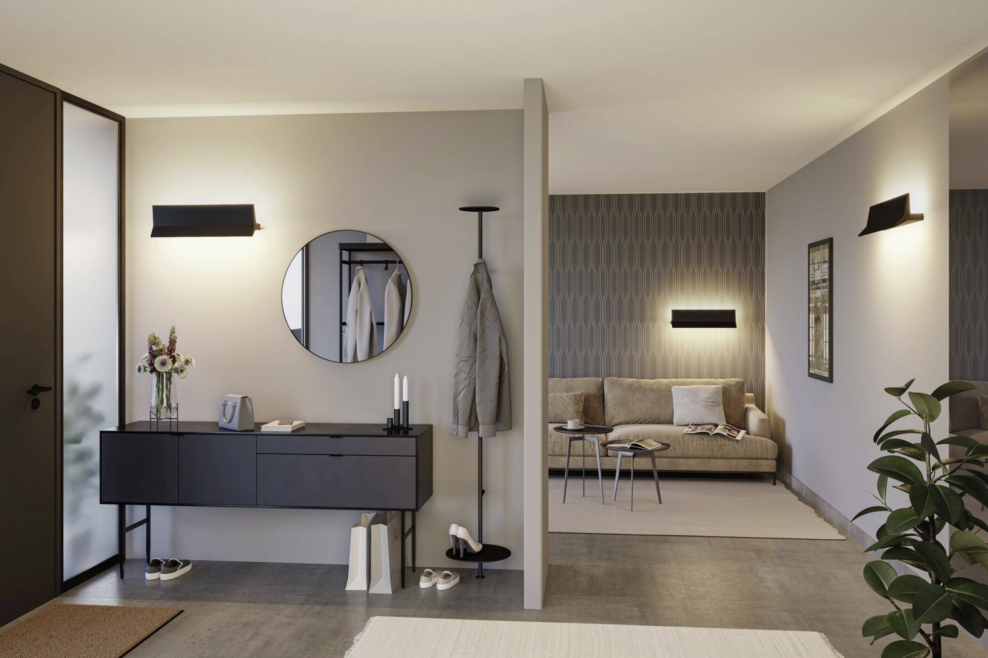 Moderný obytný priestor so svetlými stenami, okrúhle zrkadlo nad čiernou skriňou, vešiak na kabáty, pohovka v pozadí, tlmené osvetlenie.