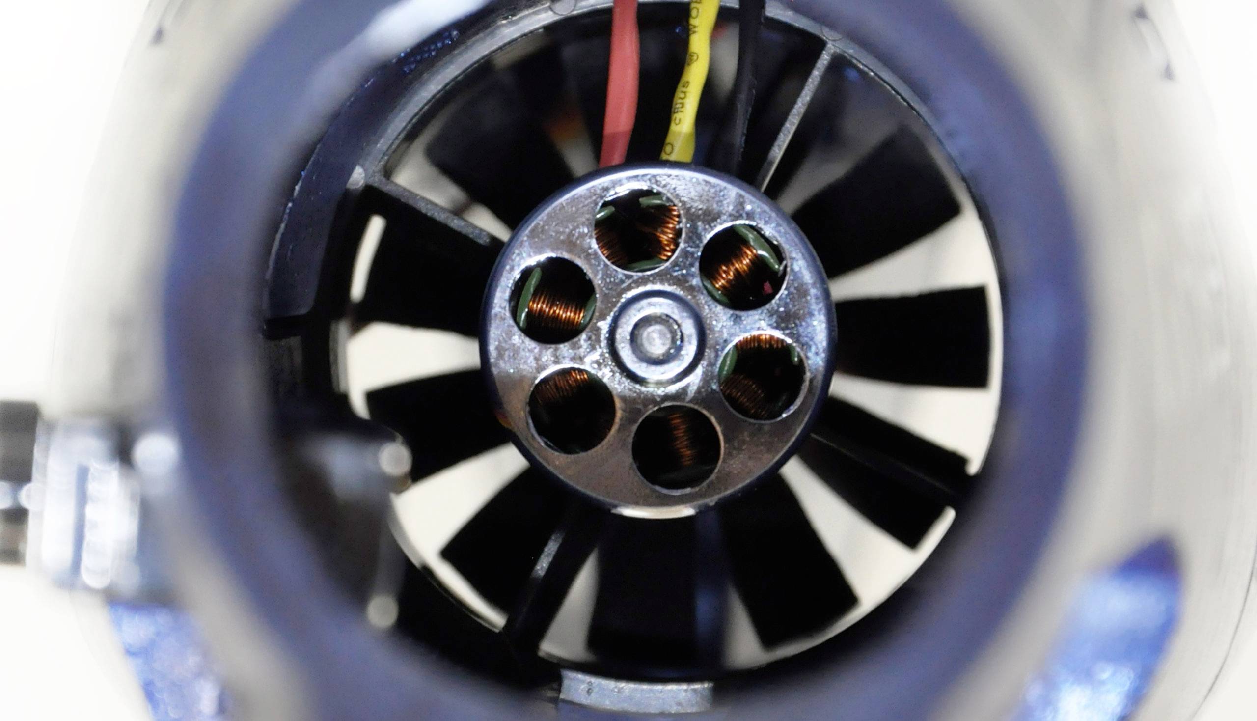 Pohľad do vnútorného rotora elektromotora so zelenými medenými cievkami a vedením. Technický pohľad zameraný na elektrotechniku.