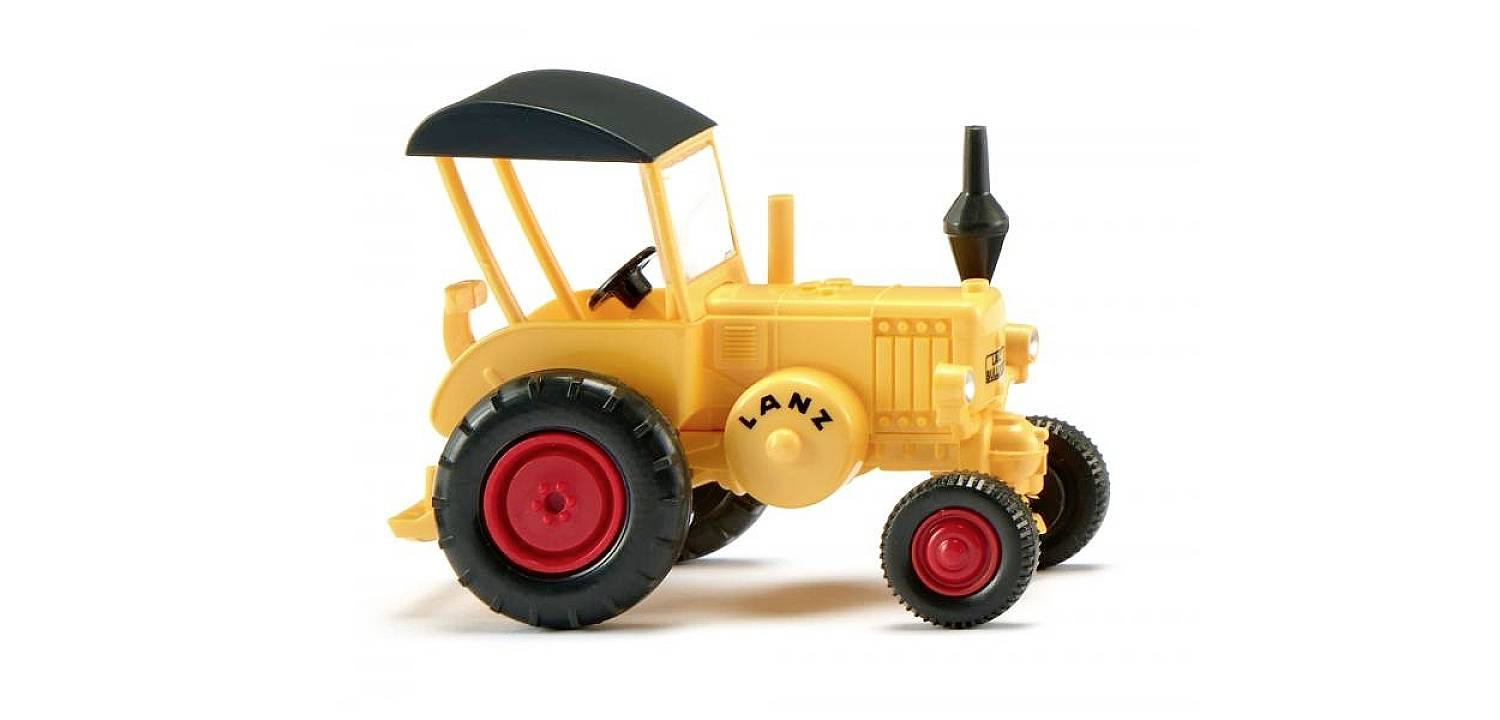 Žltý hračkársky traktor s čiernou strechou a červenými kolesami. Na kapote motora je napísané 'LANX'.
