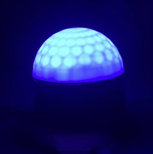 Modrá lampa s dizajnom polguľovitého tvaru vyžaruje mäkké, vzorované svetlo a vytvára upokojujúcu atmosféru.