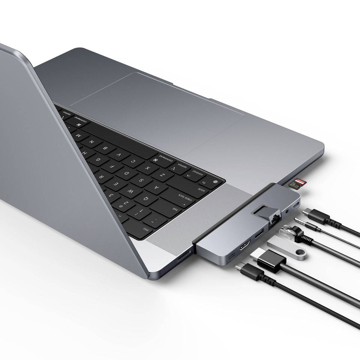Laptop s pripojeným USB-C rozbočovačom. Rozbočovač má niekoľko portov vrátane HDMI, USB-A a čítačky kariet a spája externé káble.