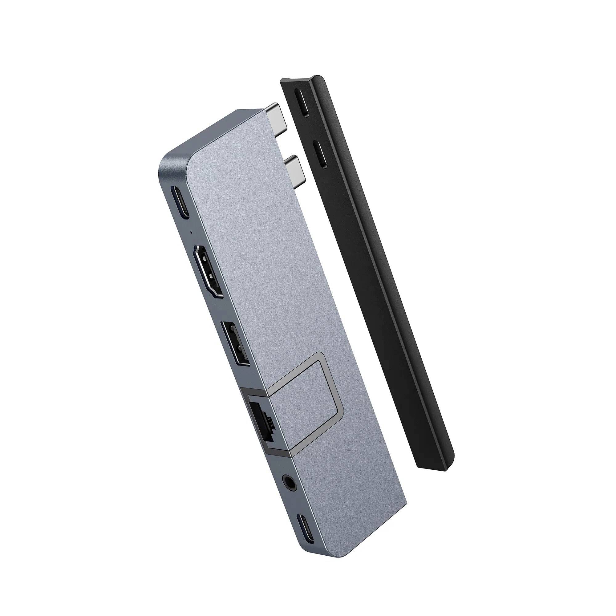 USB-C hub s HDMI, USB a ethernetovými portami, vedľa odnímateľný kryt, vhodný na rozšírenie konektorov laptopa.