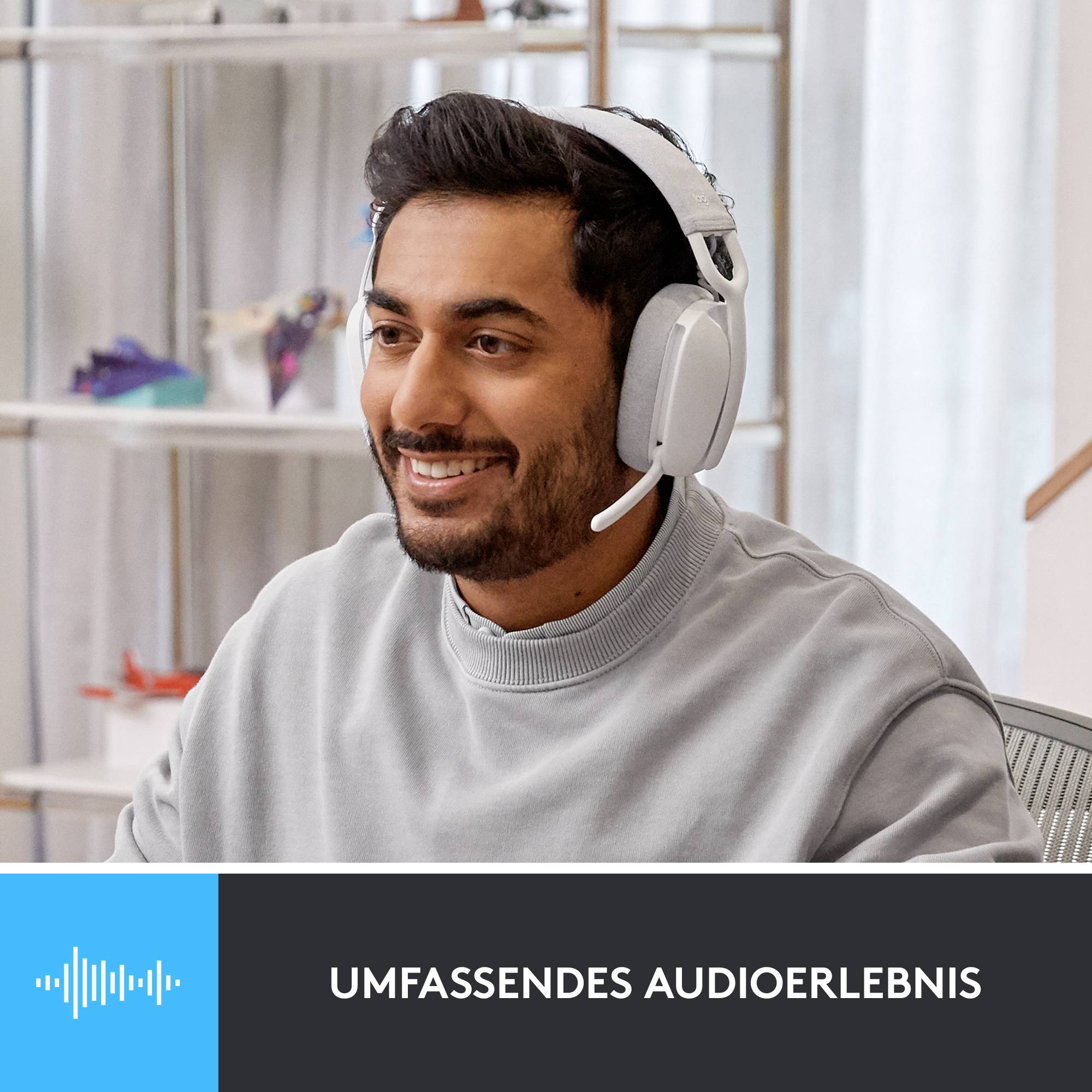 Osoba s náhlavnými slúchadlami sa usmieva v modernom priestore. Dole je napísané 'Komplexný audio zážitok'.