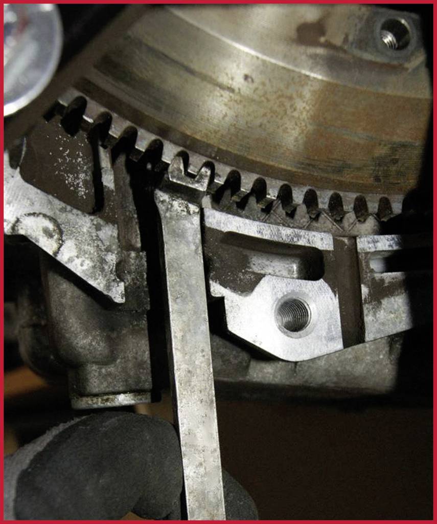 Mechanik meria vzdialenosť medzi ozubeným kolesom a kovovým meradlom na motore, aby vykonal presné nastavenia.