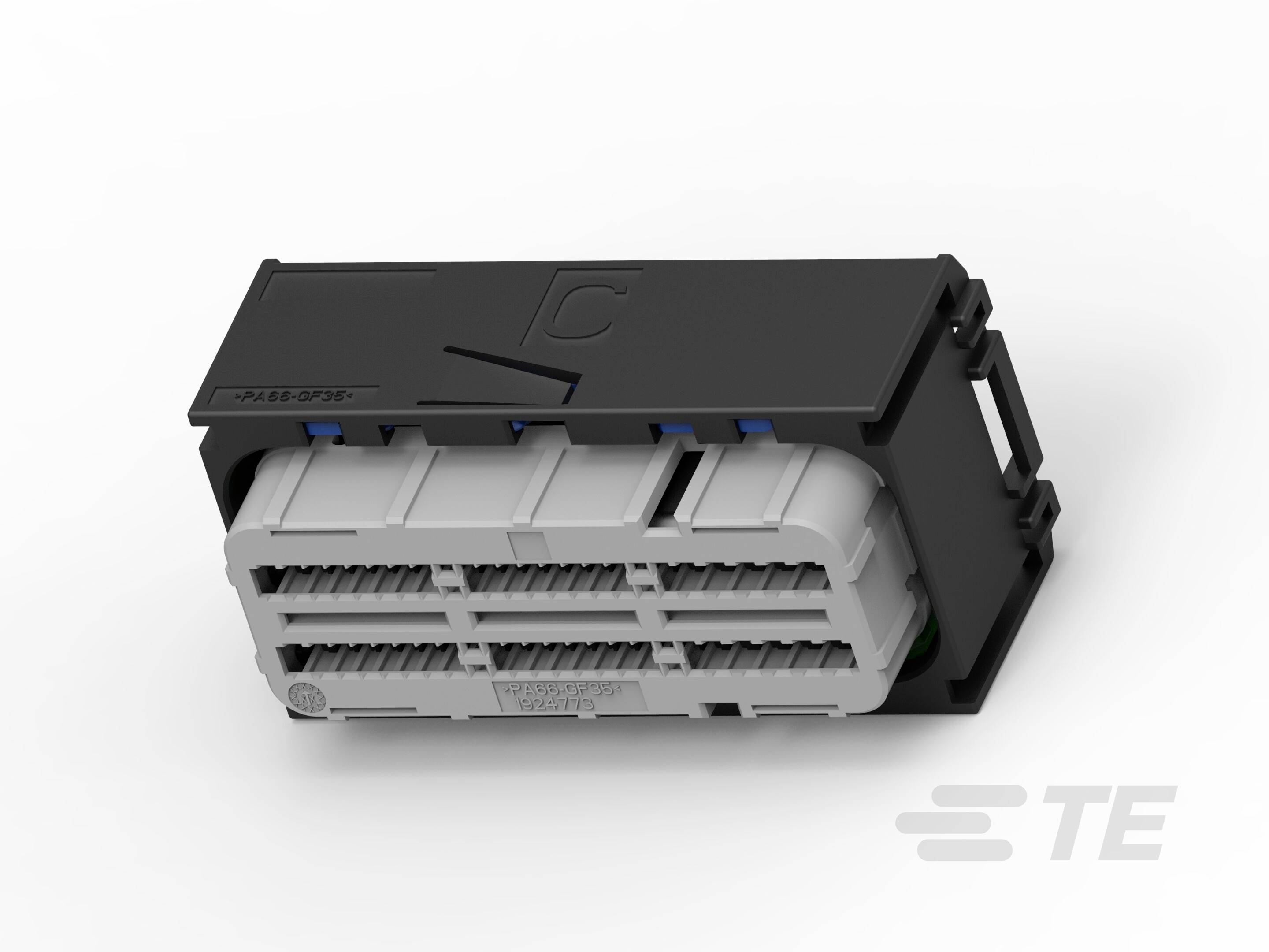 Čierne a sivé elektrické puzdro konektora s viacerými radmi pripojení, umiestnené na bielom povrchu.