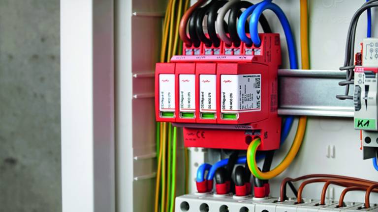 Elektrická rozvodná skriňa s červenými ističmi a nakabelovanými elektrickými obvodmi. Káble pripojené v rôznych farbách.