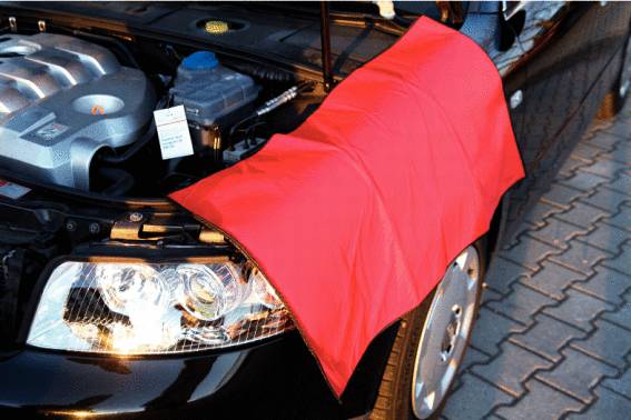 Kapota čierneho automobilu je otvorená, s červeným ochranným poťahom cez blatník, ktorý chráni pred poškriabaním počas kontroly motora.
