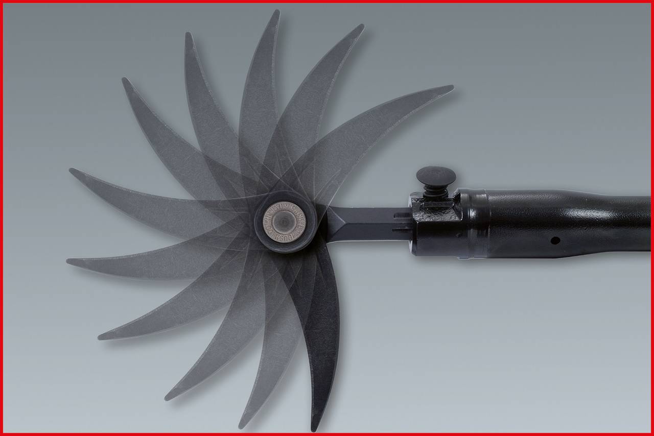 Čierny mechanický ventilátor v pohybe ukazuje zakrivené krídla cez rozmazanie pohybu. Pozadie sivé.