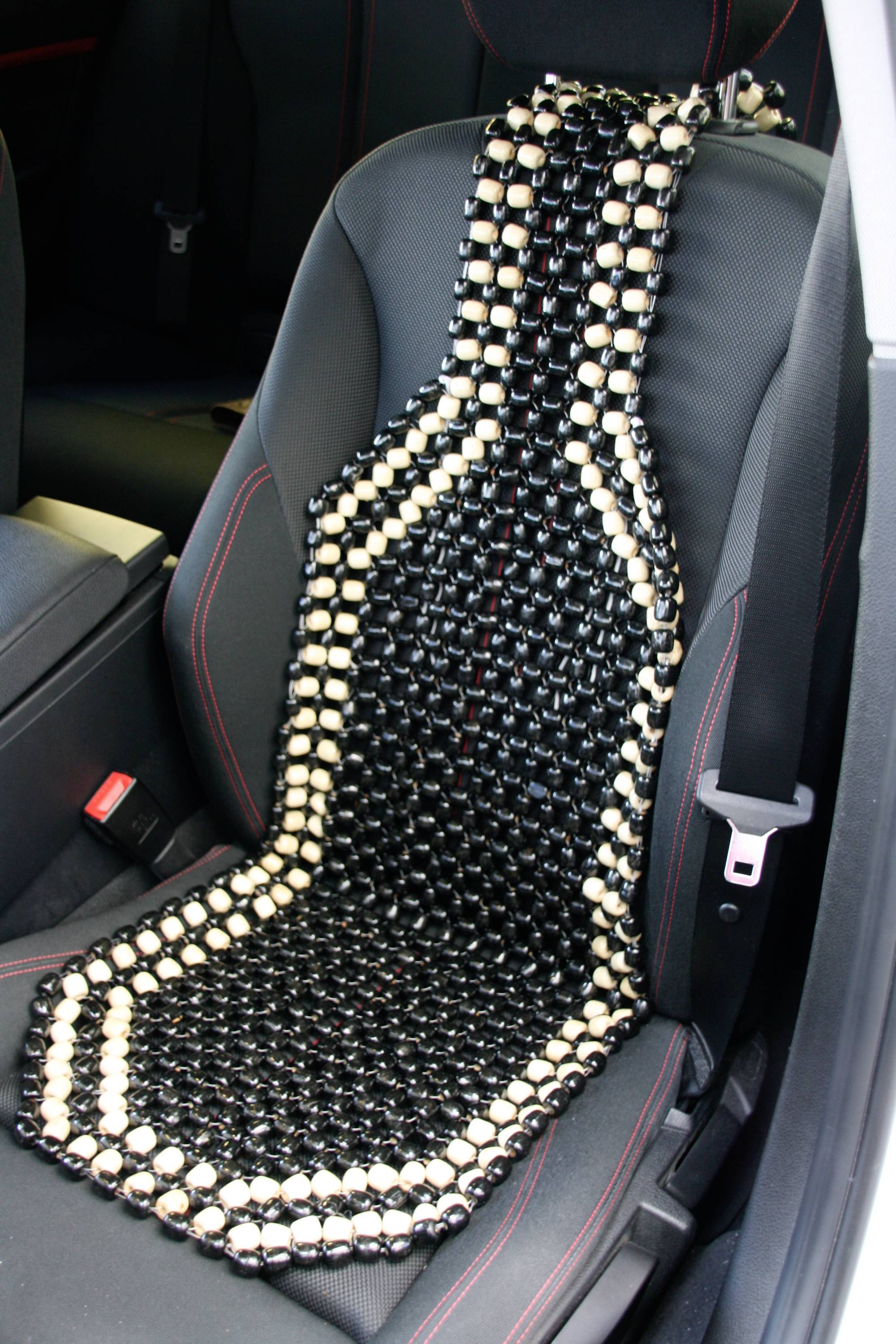 Sedák s čiernymi a svetlými drevenými guľôčkami na sedadle automobilu pre masáž a vetranie.