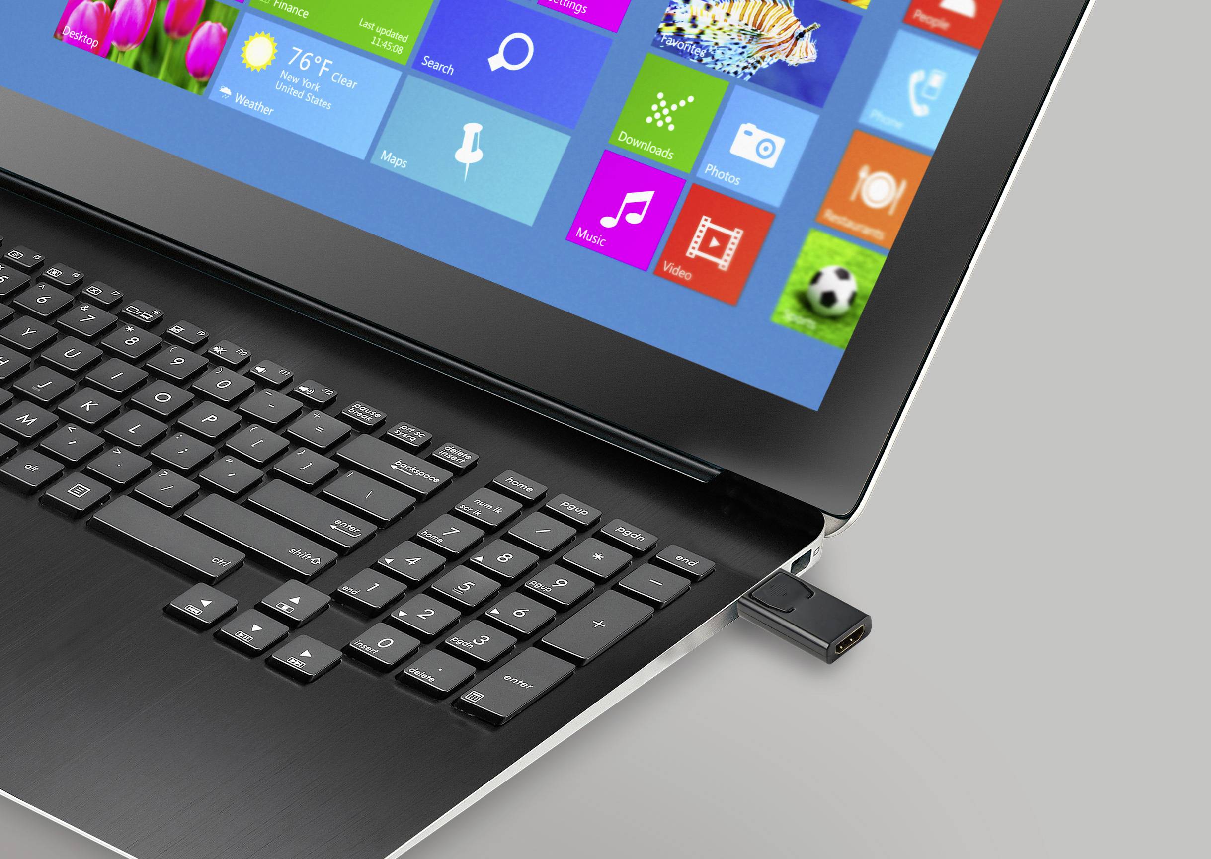 Notebook s pripojeným USB kľúčom zobrazuje pestrofarebné štartovacie menu operačného systému na obrazovke.