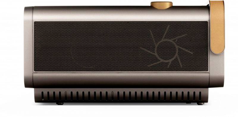 Obdĺžnikový reproduktor v bronzovej farbe s okrúhlym regulátorom hlasitosti v hornom pravom rohu a štylizovaným motívom slnka na boku.