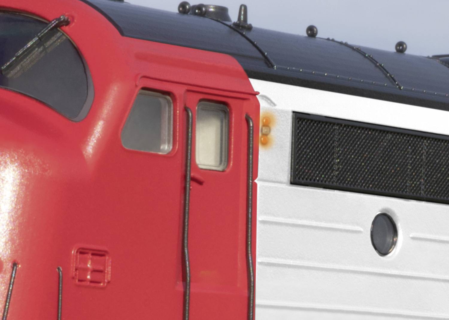 Detailný záber červeno-bielej modelovej lokomotívy s výrazným dizajnom.