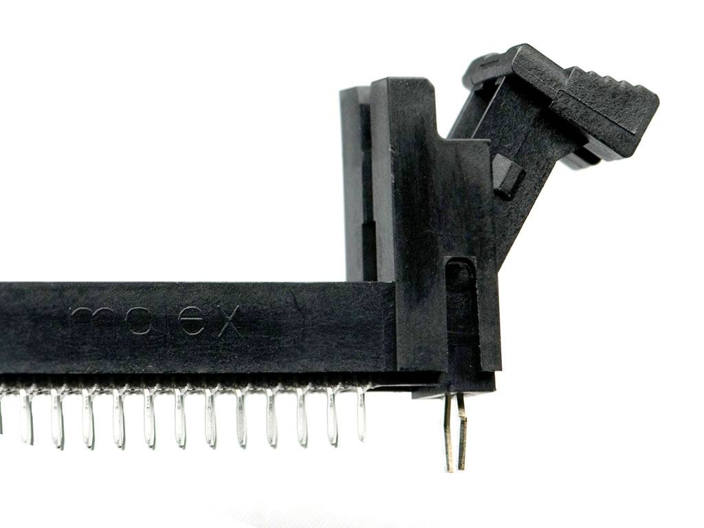 Čierny elektrický konektor s viacerými striebornými kontaktmi, fotografovaný z boku.
