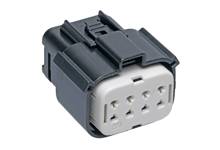 Obdĺžnikový čierny a biely elektrický konektor s viacerými otvormi, používaný na elektrické prepojenie.